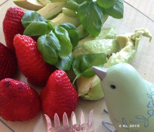 Erdbeeren, Basilikum und Avocado werden von einem kleinen Vogel bestaunt