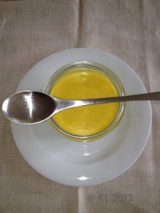 Ein Glas mit Suppe und Löffel